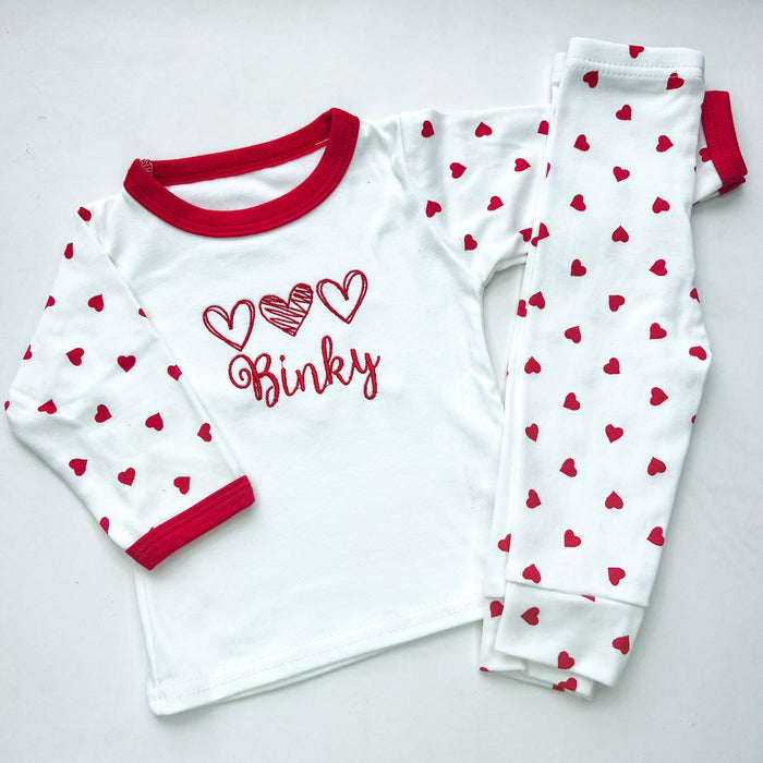 Red heart pyjamas with 3 red hearts embroidered on with the name binky