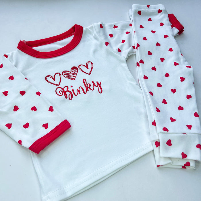 Red heart pyjamas with 3 red hearts embroidered on with the name binky
