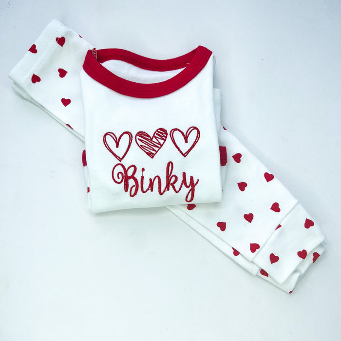 Red heart pyjamas with 3 red hearts embroidered on with the name binky