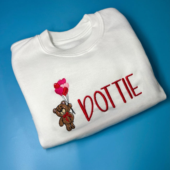 Bear with Balloons Sweatshirt - Red! White sweatshirt with a bear holding heart balloons on the front in embroidery