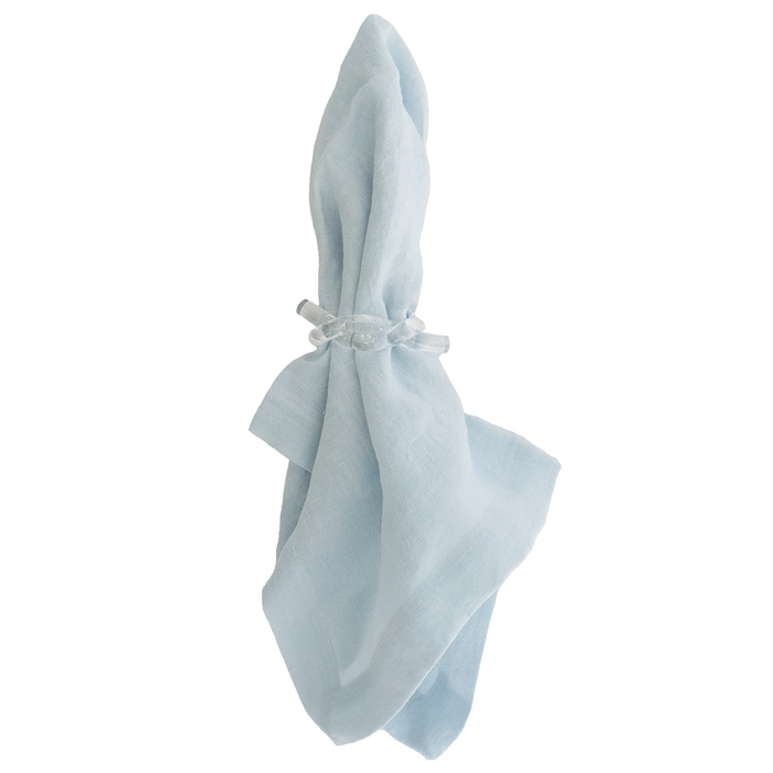 Light blue linen napkin folded and tied with a matching fabric knot.
