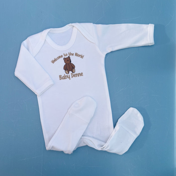 White  Baby Romper with Traditional Bear with embroidered text and bear design on a blue background