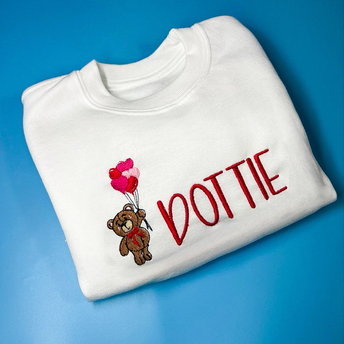 White sweatshirt with a cute bear holding heart balloons on the front