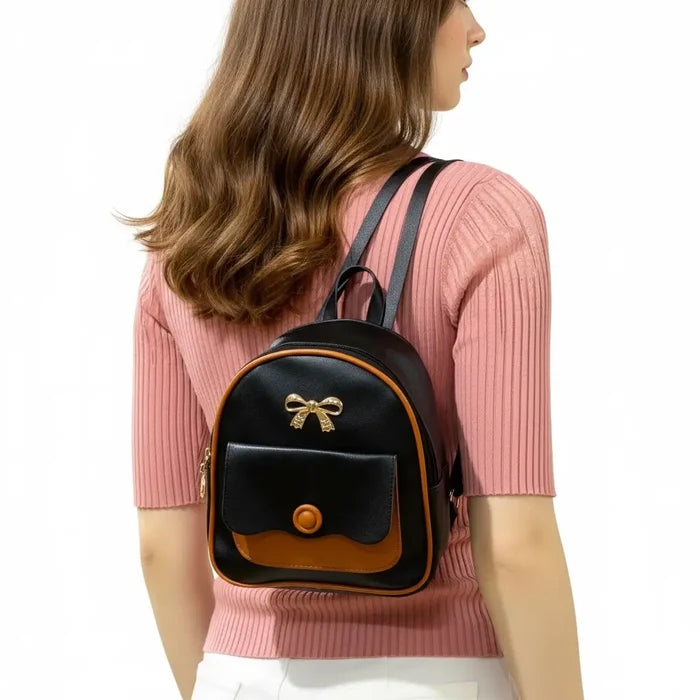 Woman carrying Black Brown Trim Mini Backpack with gold bow detail and adjustable straps / one size / women's