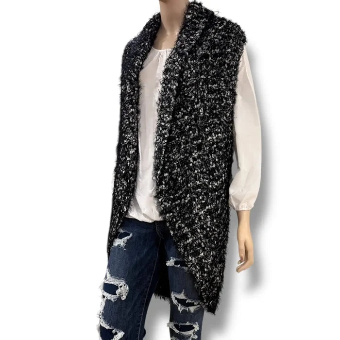 Black and white marled chunky fuzzy knit sleeveless cardigan vest with open front, rolled collar, and rounded high-low shirttail hem in sizes small and medium