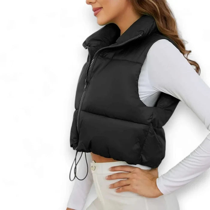 woman wearing black zip up cropped puffer vest side view