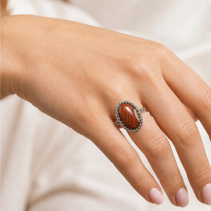 woman wearing Boho Western Burnt Orange Carnelian Silver Ring with oval lace agate and braided silver band 6.75