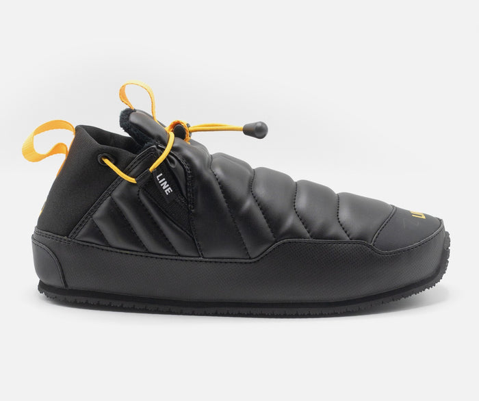 Black slip-on shoe with yellow accents on a white background
