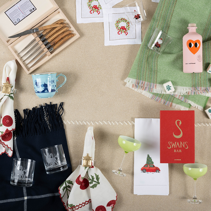 Set of four clear Bucks Rocks glasses displayed with tabletop accessories including napkins, cocktail picks, and a green.