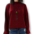woman wearing a burgundy mock neck rib knitted sweater with wide cuff sleeves