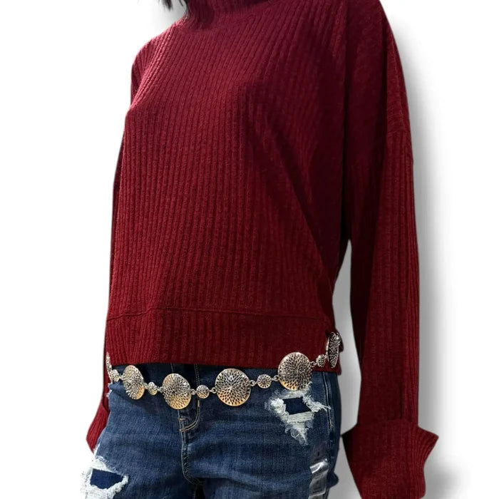 woman wearing a burgundy mock neck rib knitted sweater with wide cuff sleeves