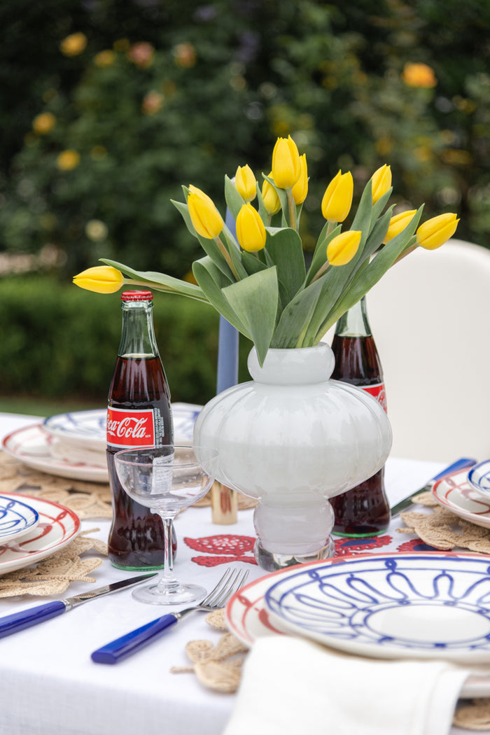 Celestial Champagne Coupe styled on table with flatware placemat dinner plate and flower vase