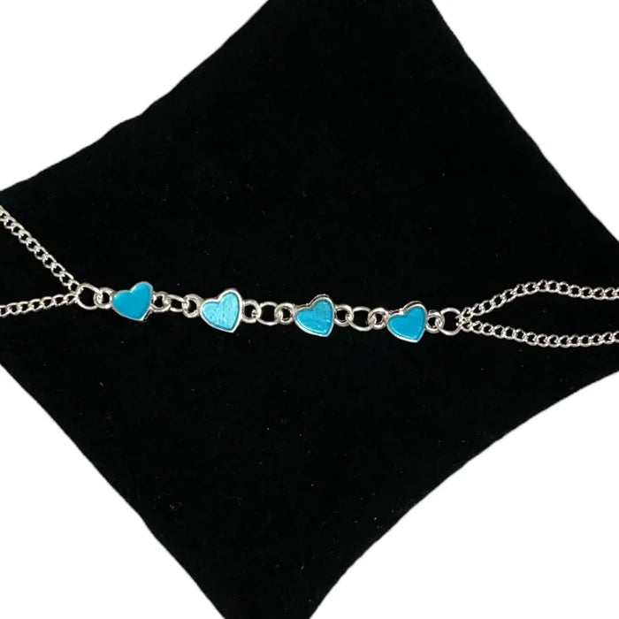 Charming hearts glow in the dark anklet with silver dual chain and glowing blue heart charms – rave, festival, and beach party body jewelry.