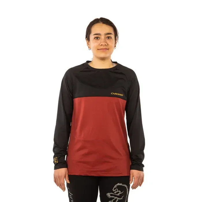 Person wearing a black and red long-sleeve shirt with a brand logo on a white background