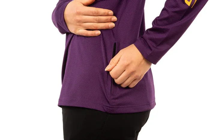 Person wearing a purple long-sleeve shirt with a yellow logo on a white background