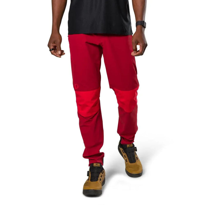 Person wearing red pants and brown boots on a white background