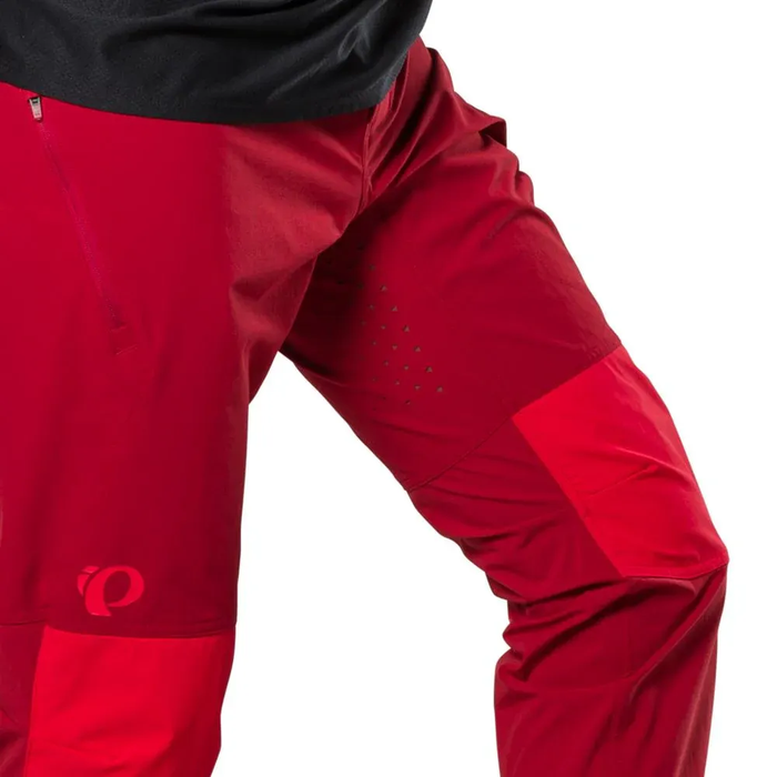 Close-up of red cycling pants with a brand logo on a white background