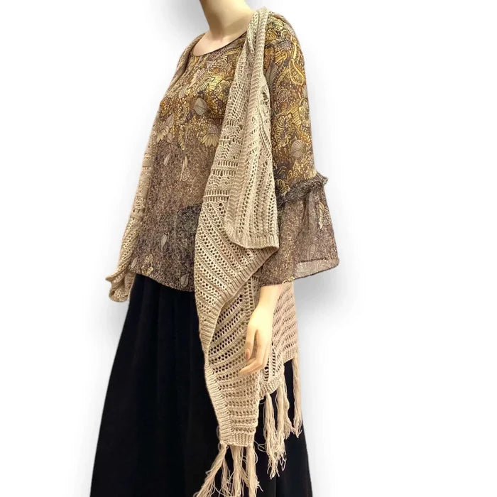 Fringe knitted sleeveless cardigan vest in tan with crochet knit texture, metallic thread accents, open front, and asymmetrical fringe hem