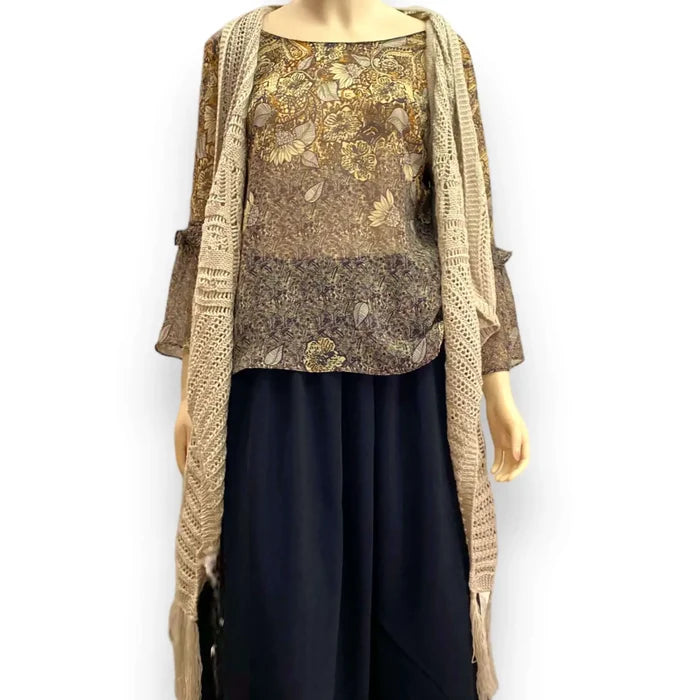 Fringe knitted sleeveless cardigan vest in tan with crochet knit texture, metallic thread accents, open front, and asymmetrical fringe hem