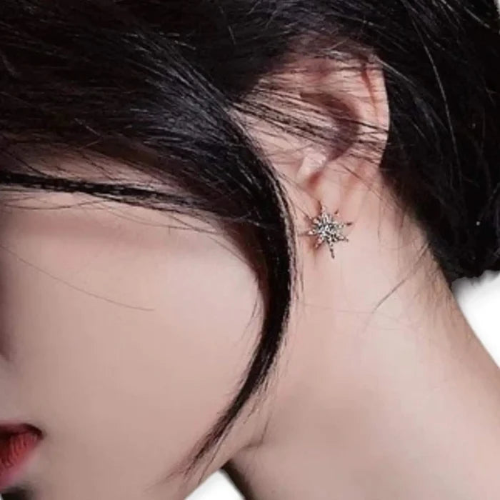 Gold Asymmetric Sparkle Moon & Star Stud Earrings showcased on a model's ear, highlighting the starburst design and golden sparkle.