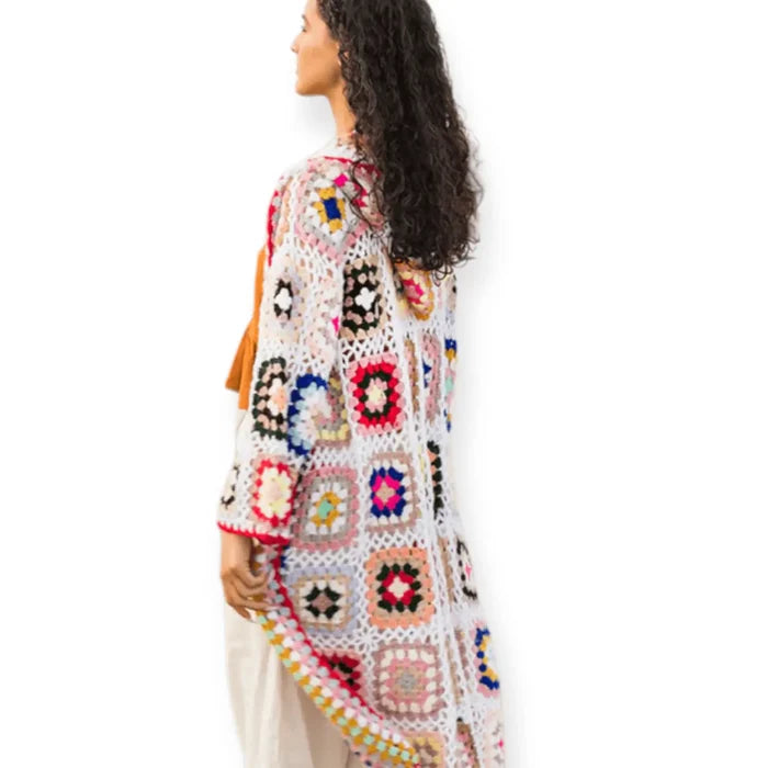 Granny square crochet long cardigan with hood displayed on a model from the side, showcasing vibrant floral motifs.