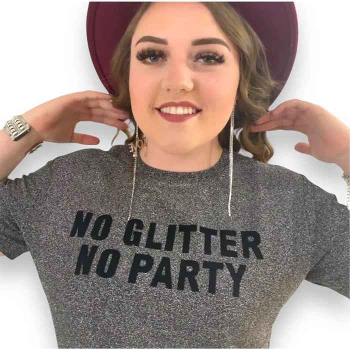 Front view on model: gray short sleeve metallic graphic tee with "NO GLITTER NO PARTY" in black lettering on chest
