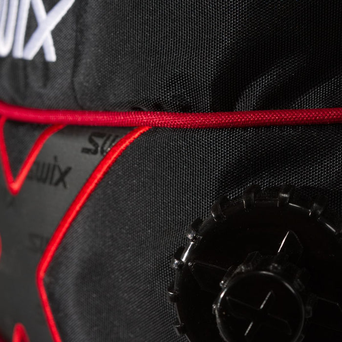 Close-up of a black and red bag with 'Swix' branding and a black valve