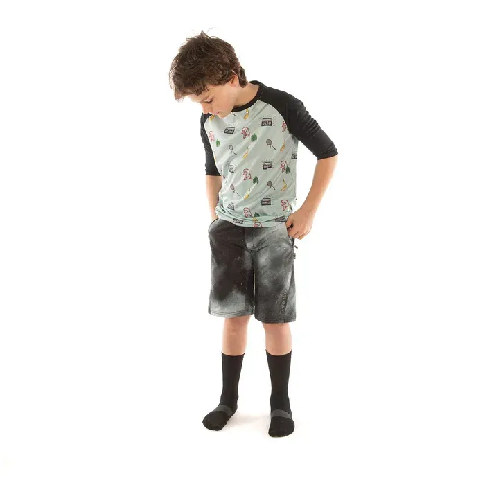 Child wearing a graphic t-shirt and shorts on a white background