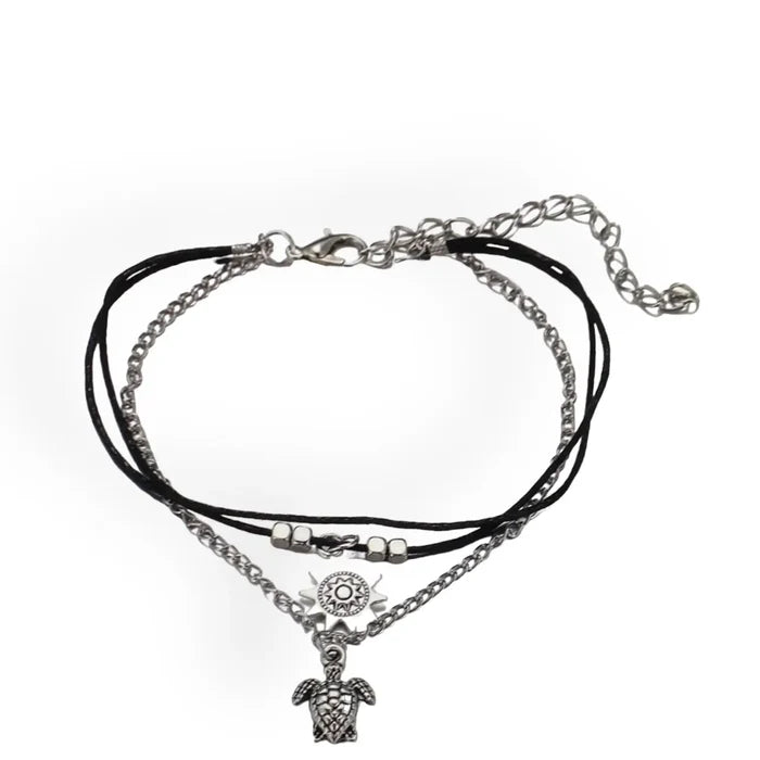 Close-up of silver turtle and sun charms on boho anklet