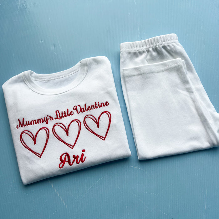 White pyjamas with mummy’s little valentine embroidered on the front with 3 hearts