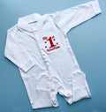 White baby romper with red text saying my 1st valentine on a blue background