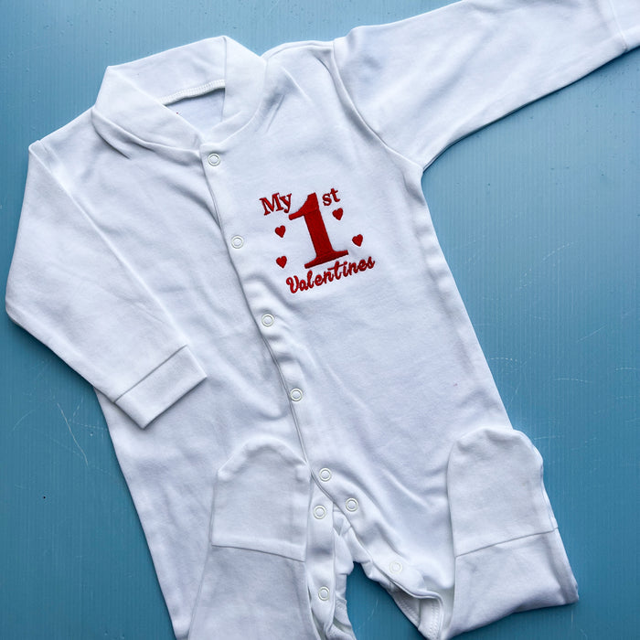 White baby onesie with red text on a blue background