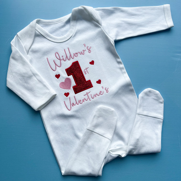 White baby onesie with Valentine's Day design on a blue background