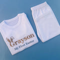 White pyjamas with Grayson first Easter embroidered on with bunny ears