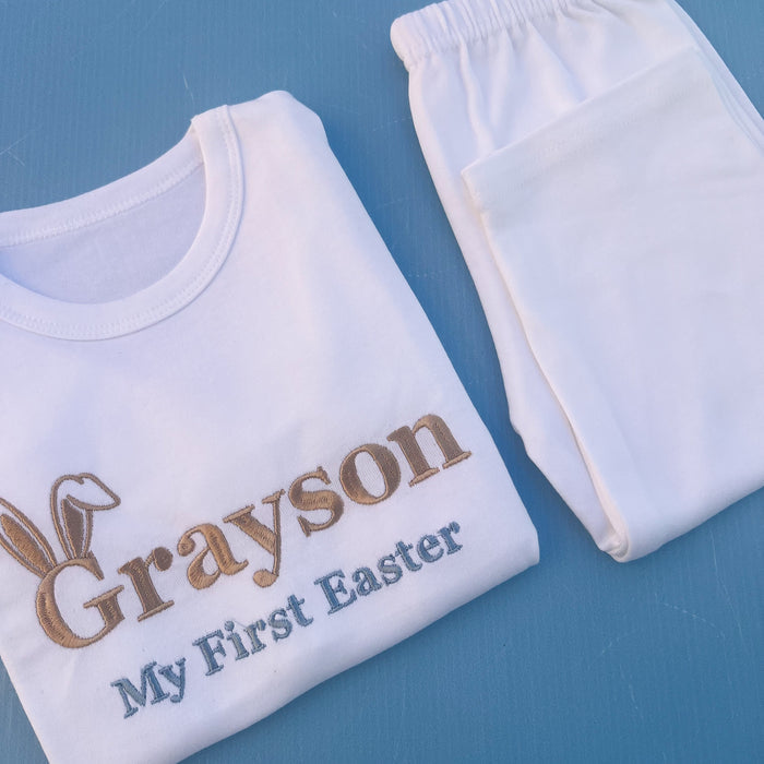 White pyjamas with Grayson first Easter embroidered on with bunny ears