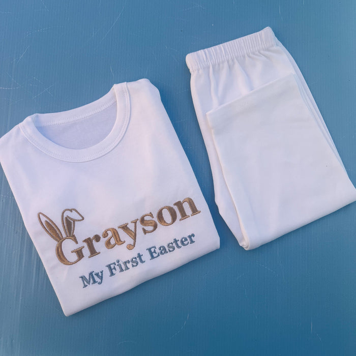 White pyjamas with Grayson first Easter embroidered on with bunny ears