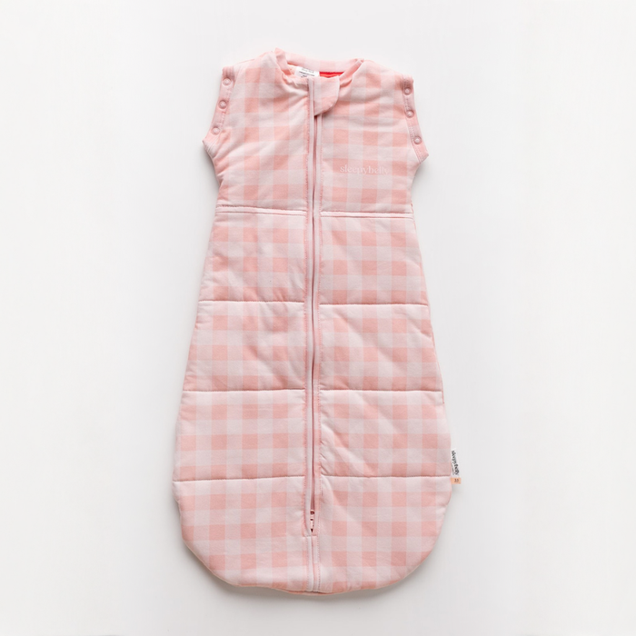 Pink gingham newborn swaddle sack laid flat showing the centre two-way zip