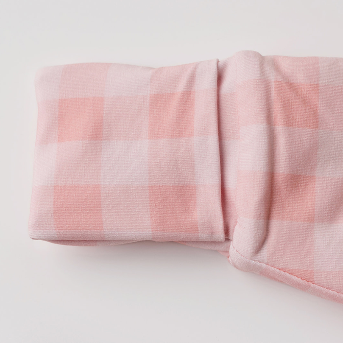 Close-up of the soft pink gingham organic cotton fabric and cuff on the Sleepybelly infant sleep sack