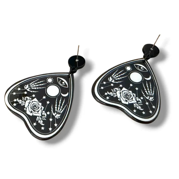 Occult Rose Planchette Earrings in black acrylic with white skeleton hands, rose, eye, moon, and star graphics back side