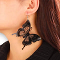 Oversized black butterfly dangling earrings with 3D layered wings in black and clear plastic – statement fairycore and Halloween jewelry