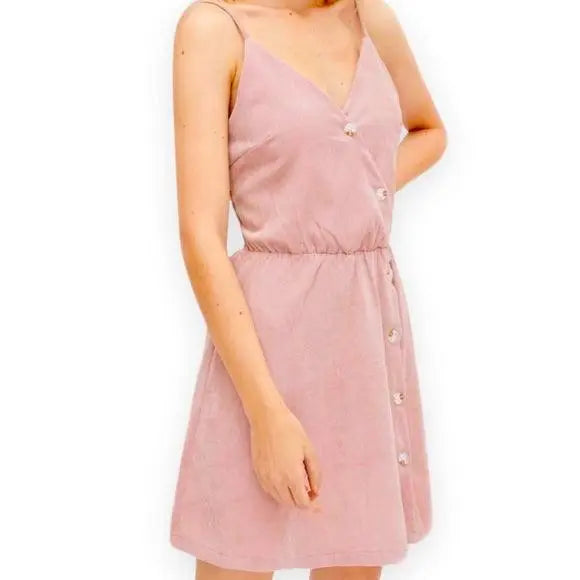Pink Corduroy Summer Mini Dress with V-neckline, smocked back, adjustable straps, and asymmetric button detail side view on model