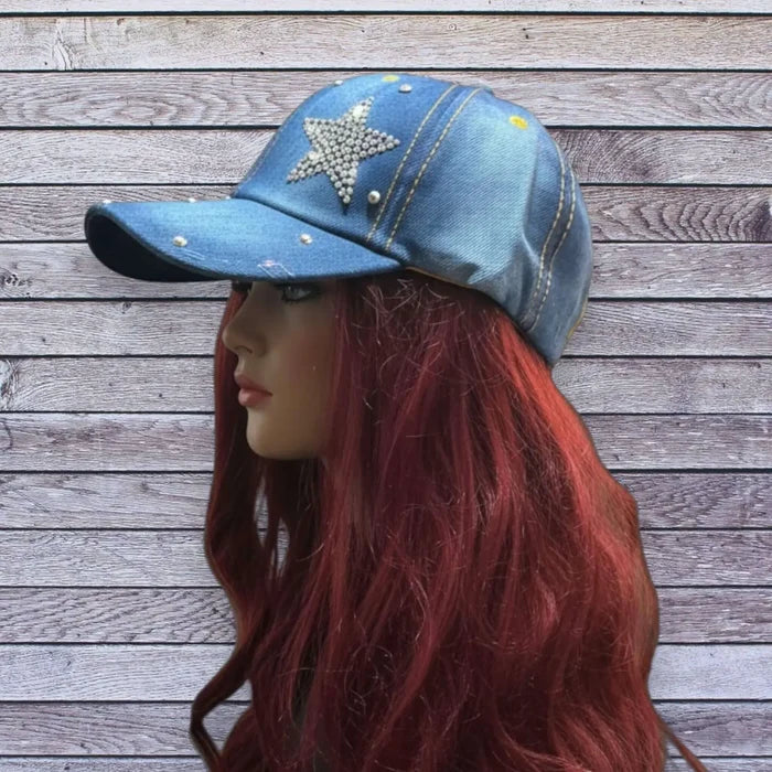 Dark blue denim baseball cap with rhinestone star and silver stud detailing on front and brim, curved stiff brim, adjustable back strap, head size 21 to 24 inches