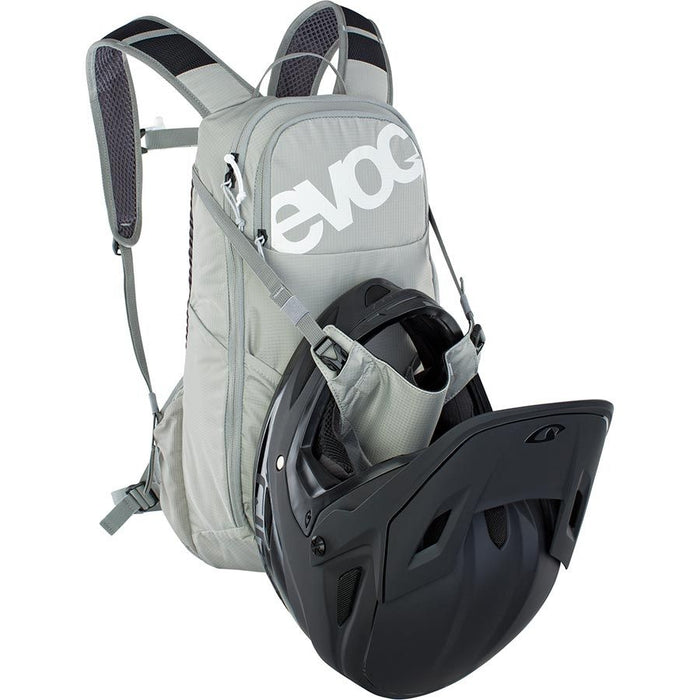 Gray backpack with a black helmet attached on a white background, featuring the Evoc brand.