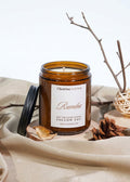 Scented candle in amber glass jar with Rumba label and wooden wick