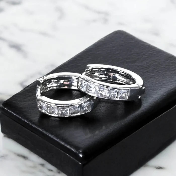 flat lay on jewelry box Silver Crystal Hinge Hoop Earrings with channel-set zirconia, huggie shape, and secure click-latch closure