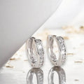 pair of Silver Crystal Hinge Hoop Earrings with channel-set zirconia, huggie shape, and secure click-latch closure