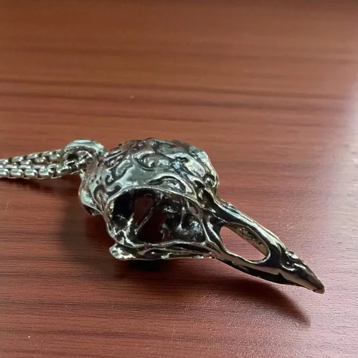 flat lay on wood table silver raven skull pendant necklace stainless steel box chain crow box chain 22"