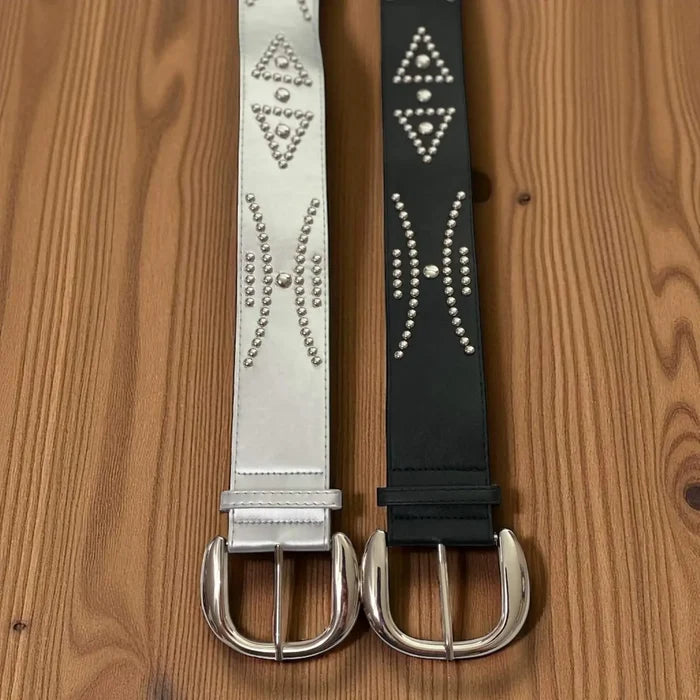 Silver studded oversize buckle wide belt with tribal rivets and wide faux leather strap black or metallic on wood background