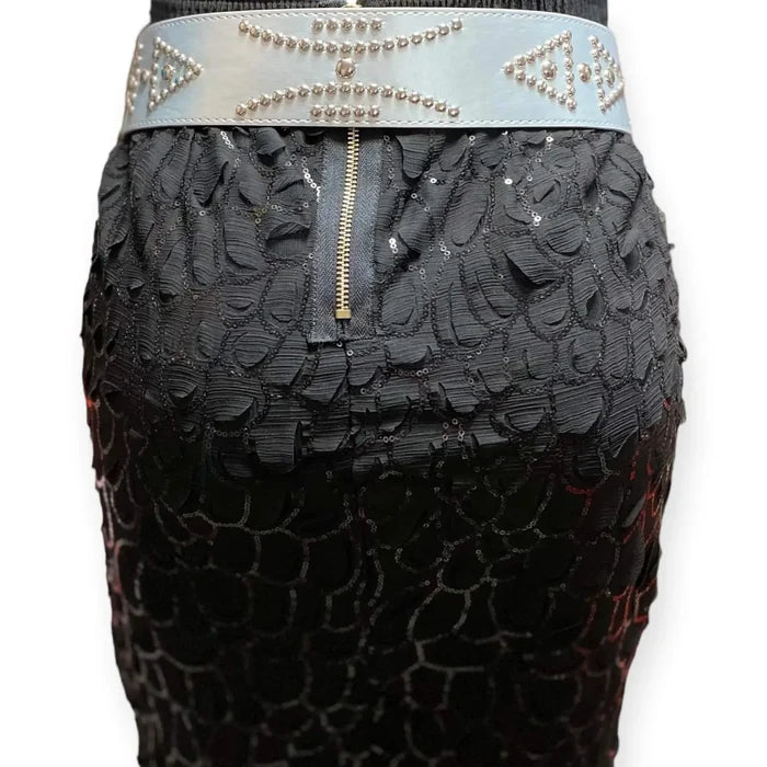 Silver studded oversize buckle wide belt with tribal rivets and wide faux leather strap backside on skirt on white background