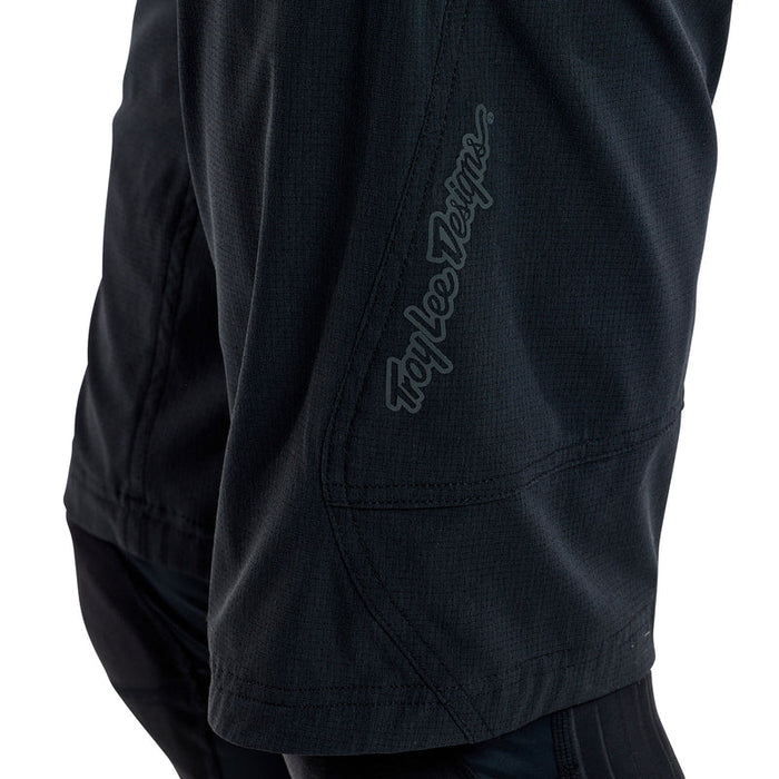 Black shorts with a brand logo on the sleeve against a white background